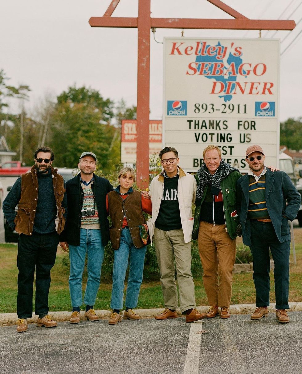 a group of people posing for a photo in front of a sign