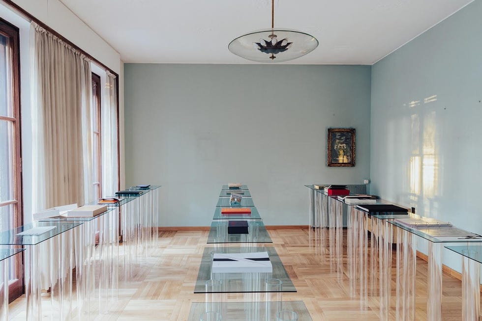 exhibition space featuring various books displayed on glass tables