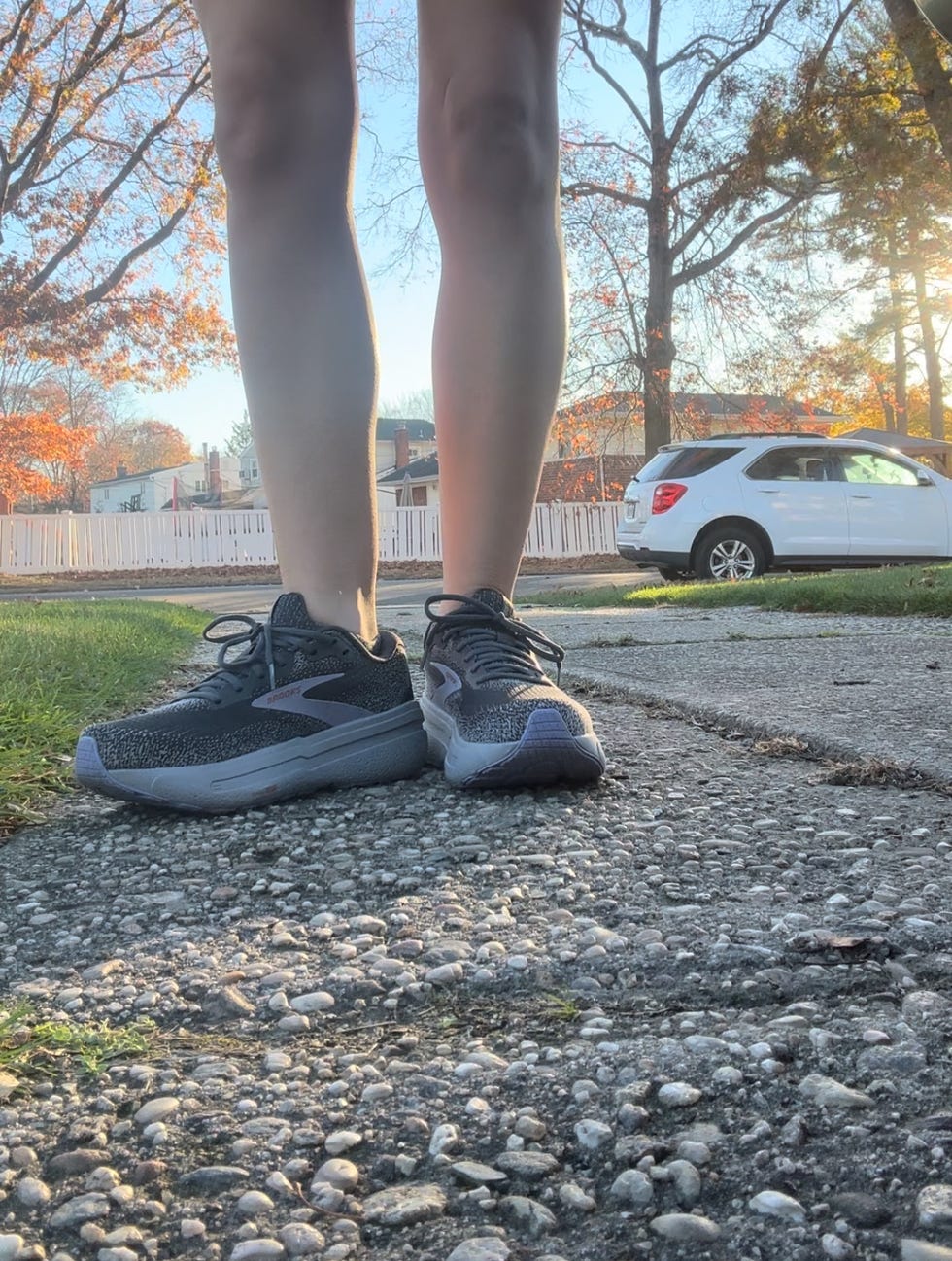 a shot of a woman's legs wearing brooks running shoes outside on a driveway