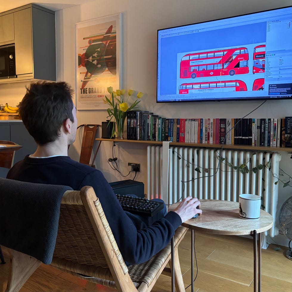 seated person working on a computer design programme in a home setting