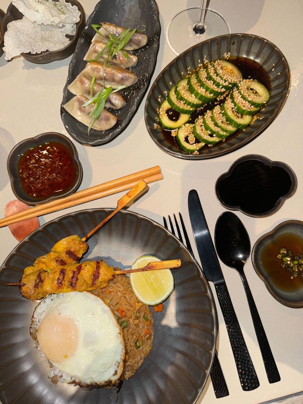 an asianinspired meal featuring skewers fried rice and various sides
