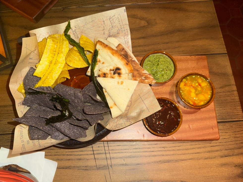 an appetizer with chips, breads and dips at the beak and barrel