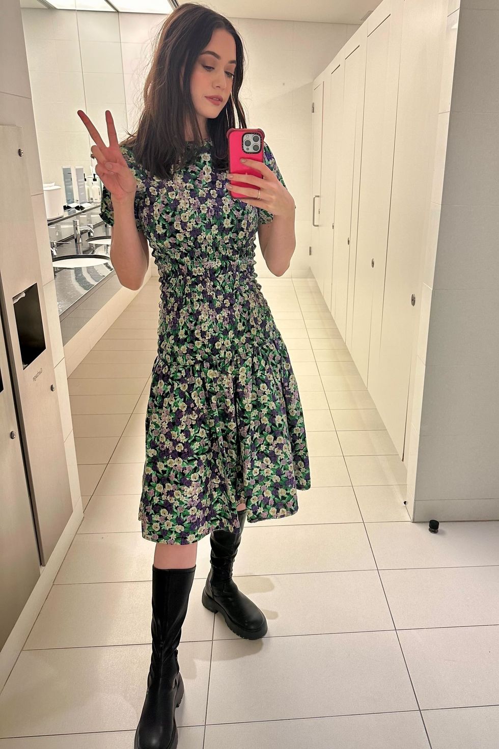 a gh analyst in a green and purple floral dress taking a selfie in the mirror