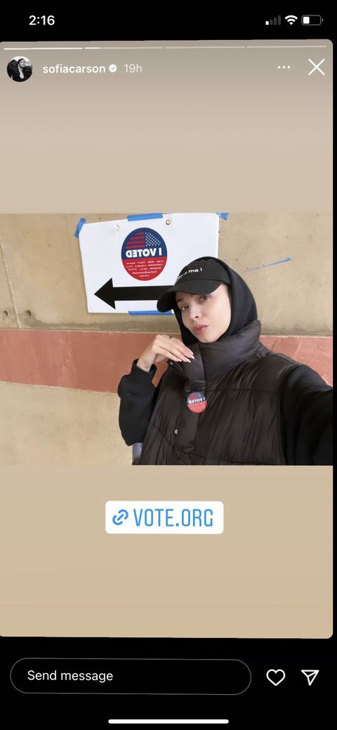 sofia carson posing with her i voted sticker and near an i voted sign
