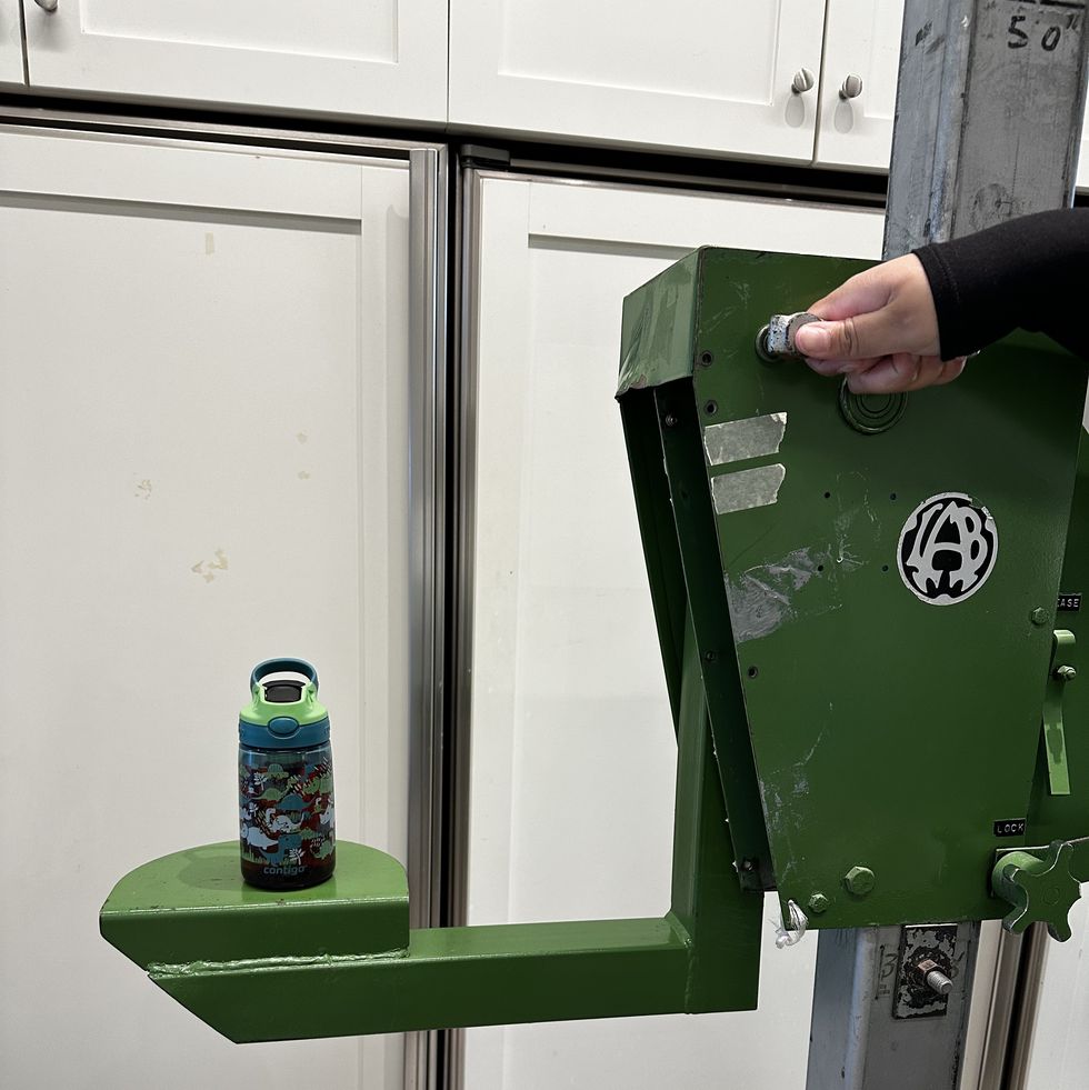 water bottle with dinosaur design sitting on green drop test machine