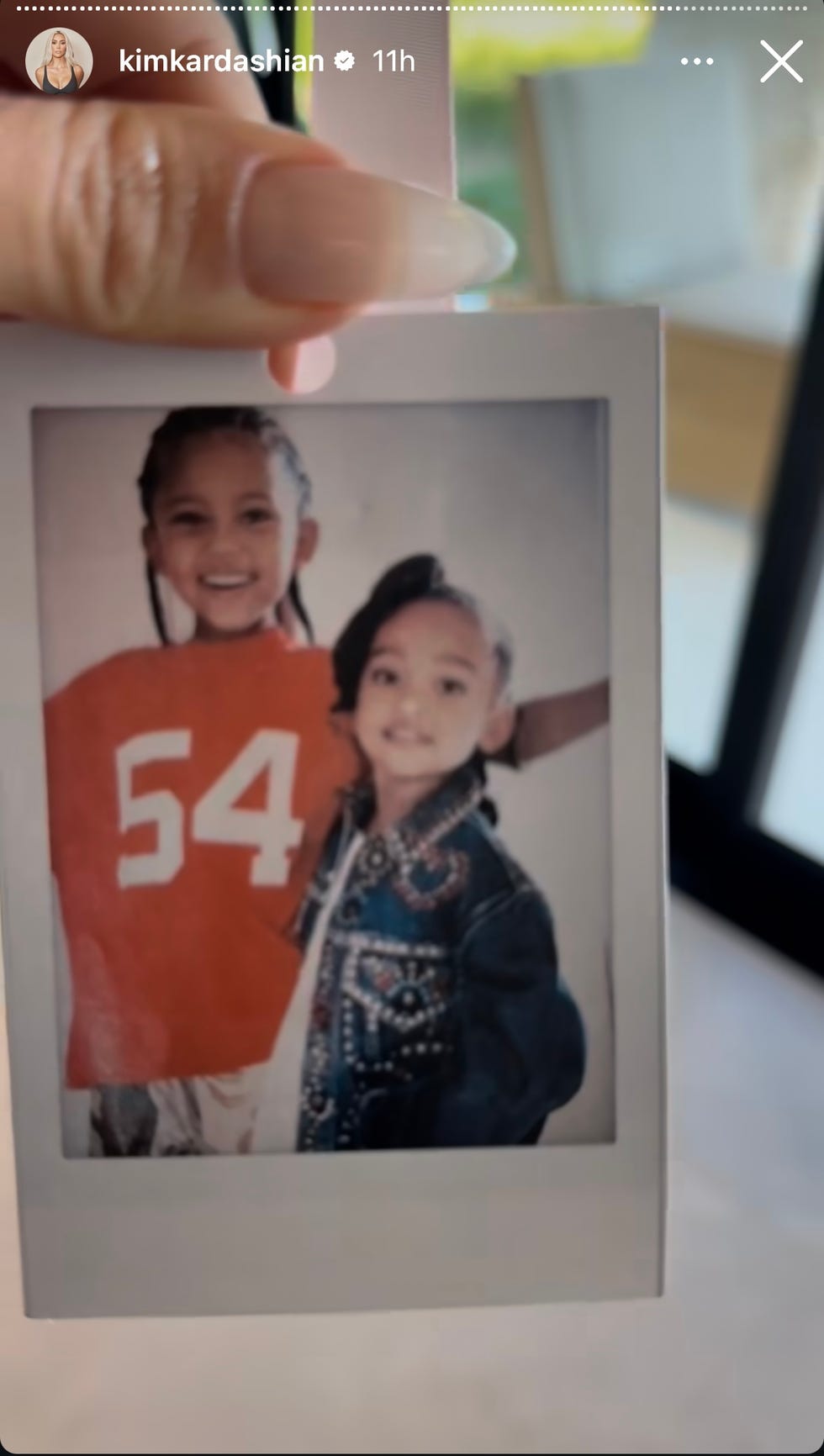 A Polaroid photo shows two children