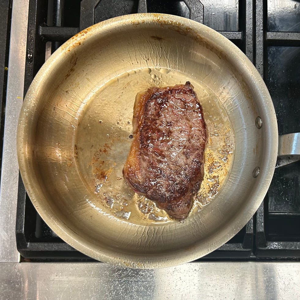 steak in a stainless steel pan steak in a stainless steel pan