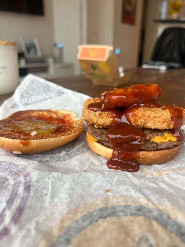 assembled mcdouble sandwich with sauce and a top bun aside
