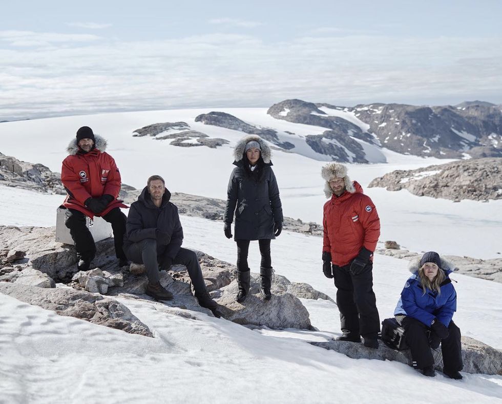 a group of people posing on a snowy mountain