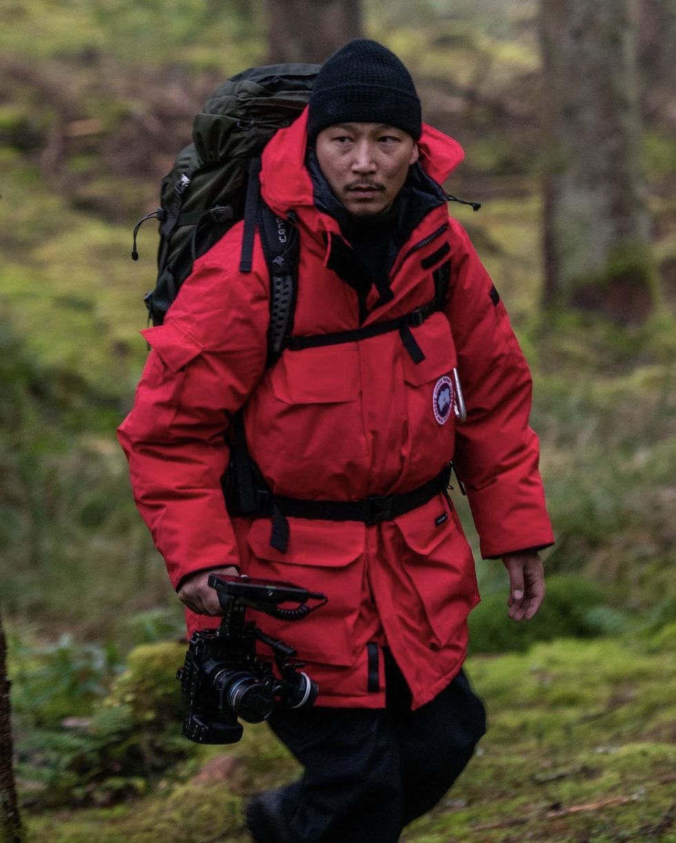 a person wearing a red jacket and holding a camera