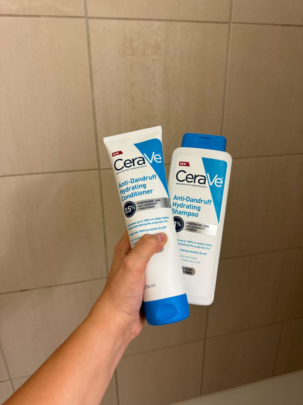 cerave antidandruff shampoo and conditioner held in hand