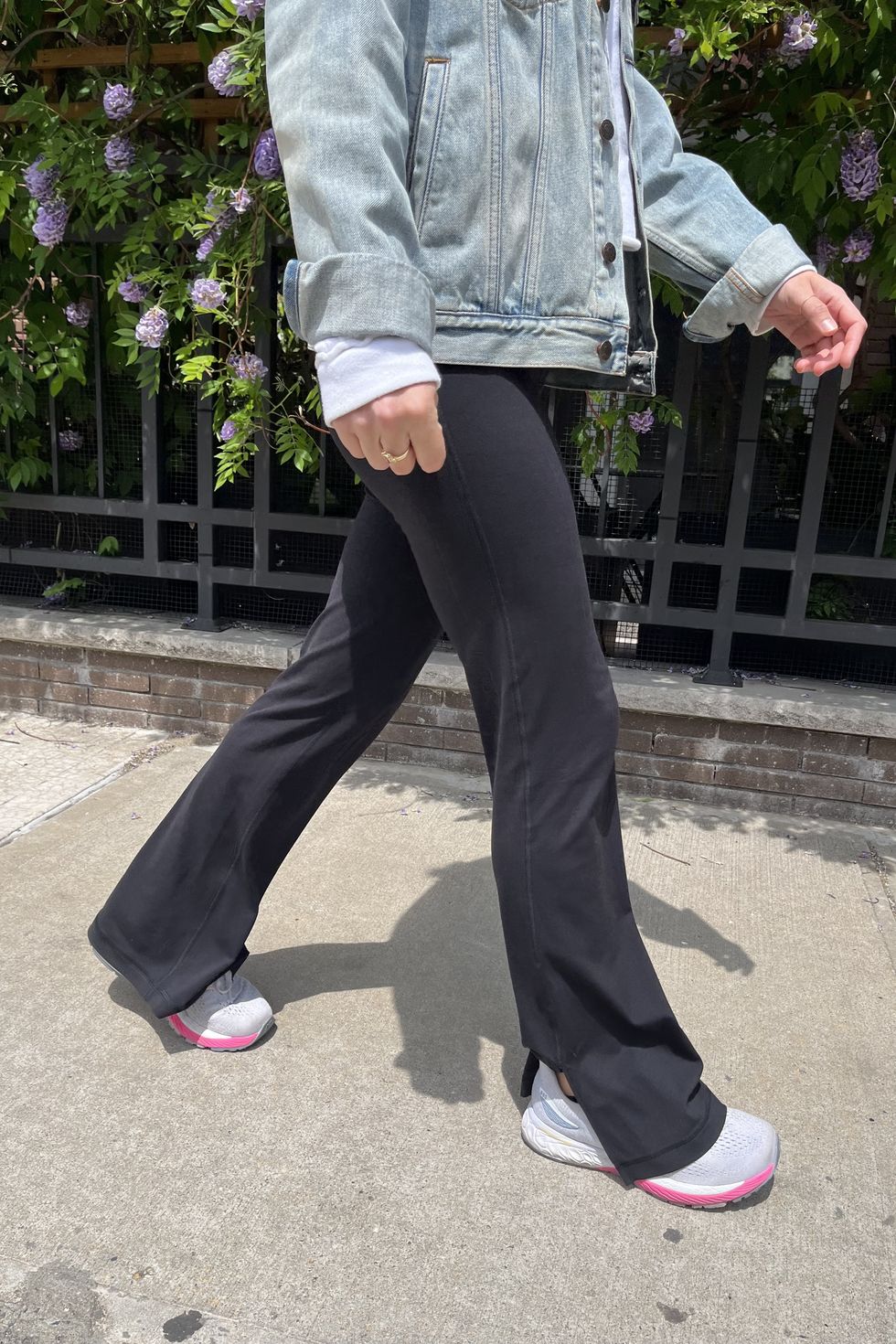a model wearing black lululemon split hem leggings with white sneakers on the sidewalk, good housekeeping's testing for best lululemon leggings