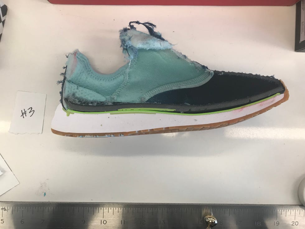 a shoe is sawed in half on a white testing table so the inner foam and construction is visible
