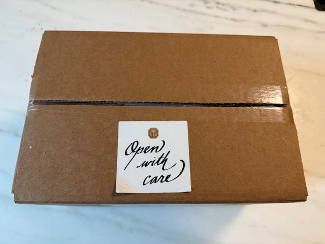 a cardboard box with a label indicating to open it carefully