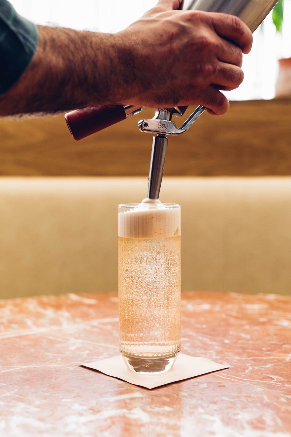 a person pouring a liquid into a glass