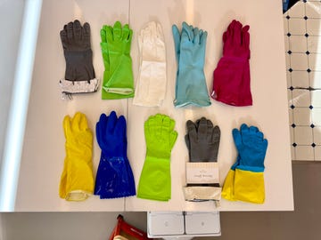 multiple pairs of dishwashing gloves in a variety of colors on a white counter