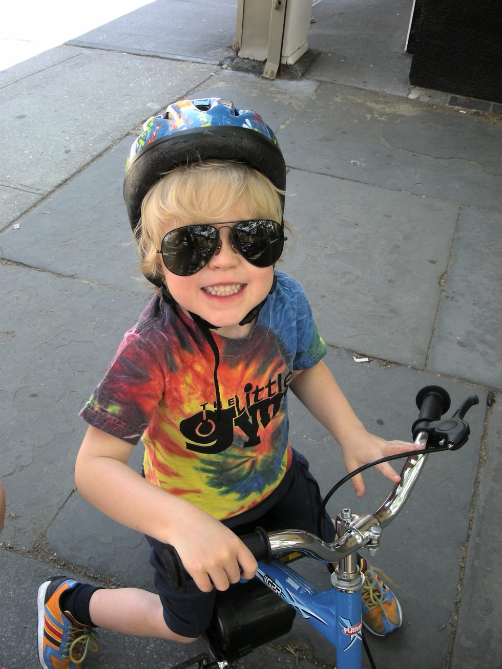 child sitting on a small balance bike wearing a helmet
