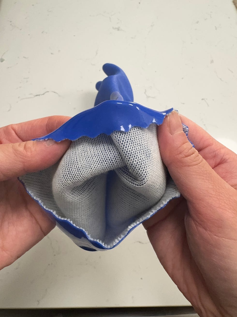 person holding a glove turning the glove inside out to show inner lining