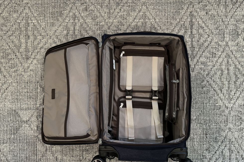 a checked suitcase from travelpro lying open on the floor