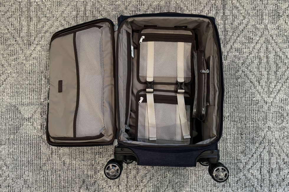a checked suitcase from travelpro lying open on the floor