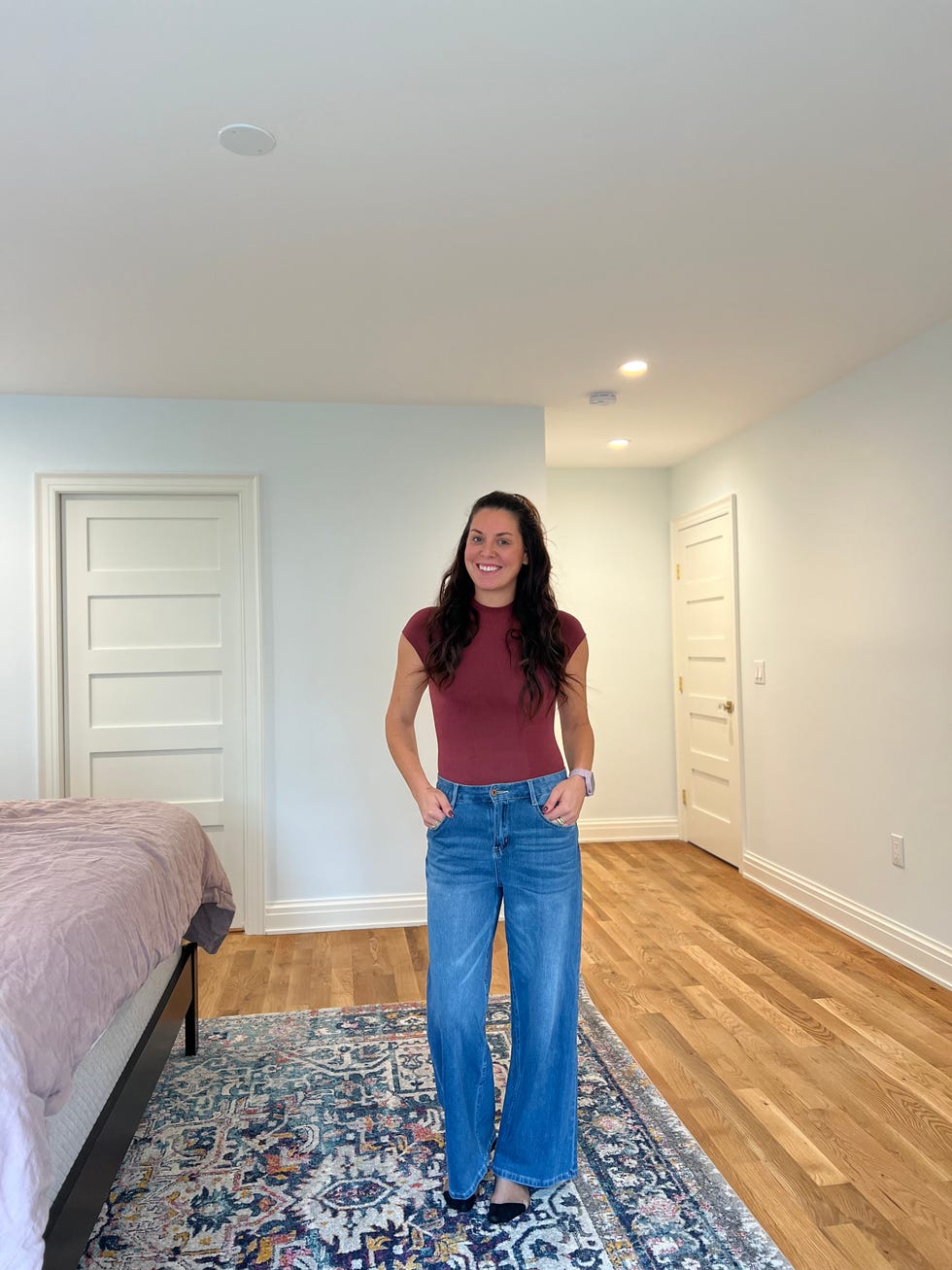 person wearing a fitted top and wideleg jeans standing in a room