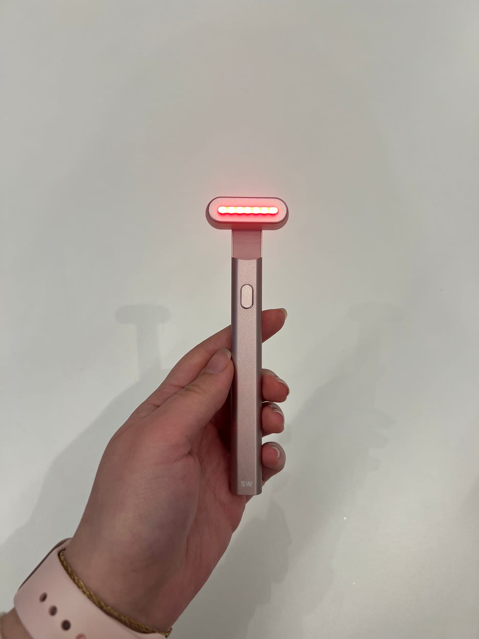 a hand holding a solawave skincare wand