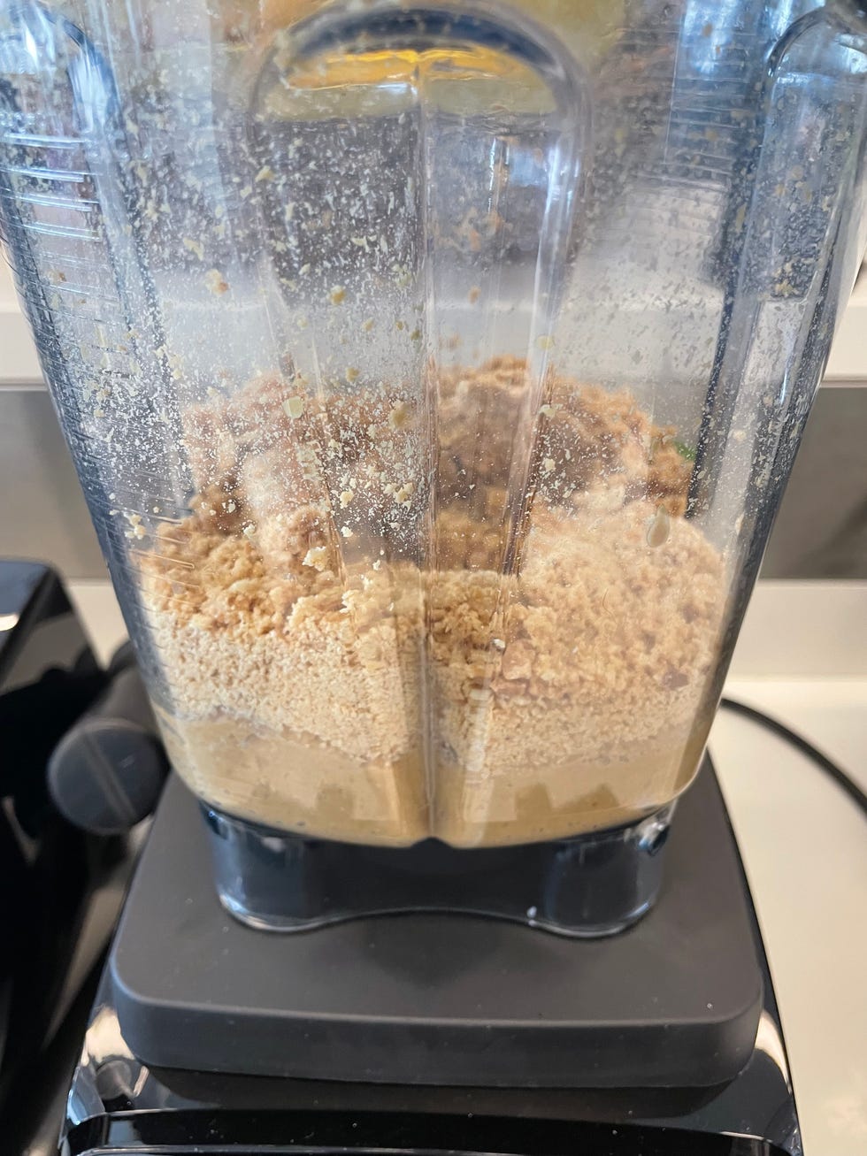 peanuts inside of a blender, half ground