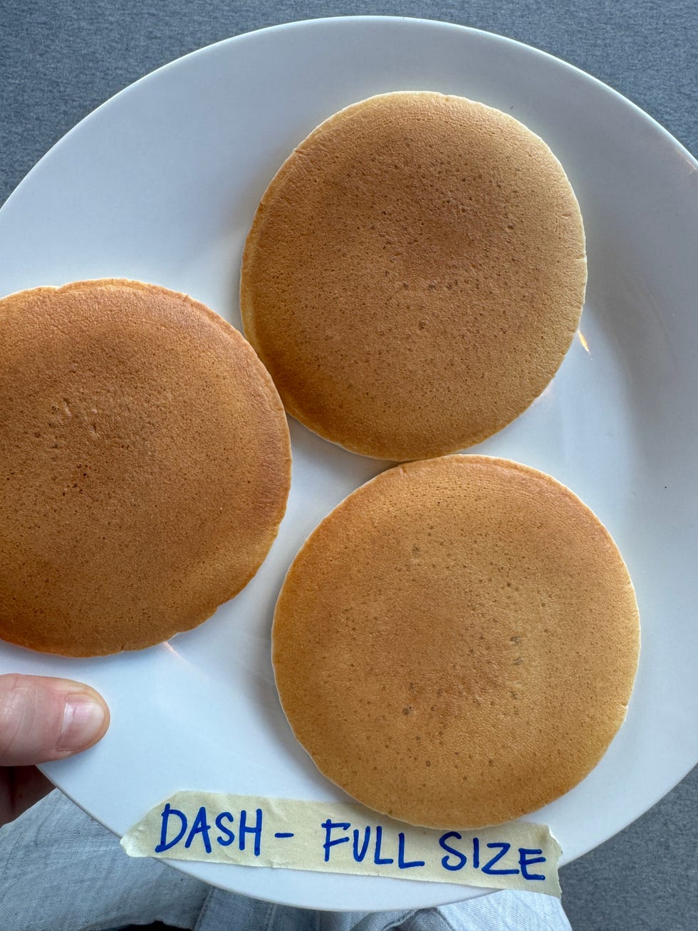 a plate with three round golden brown pancakes