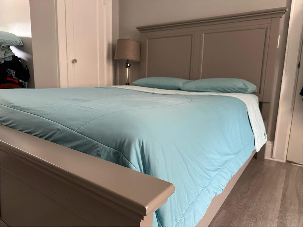 a gray wooden bed with the rest evercool cooling comforter in aqua blue and matching blue pillows