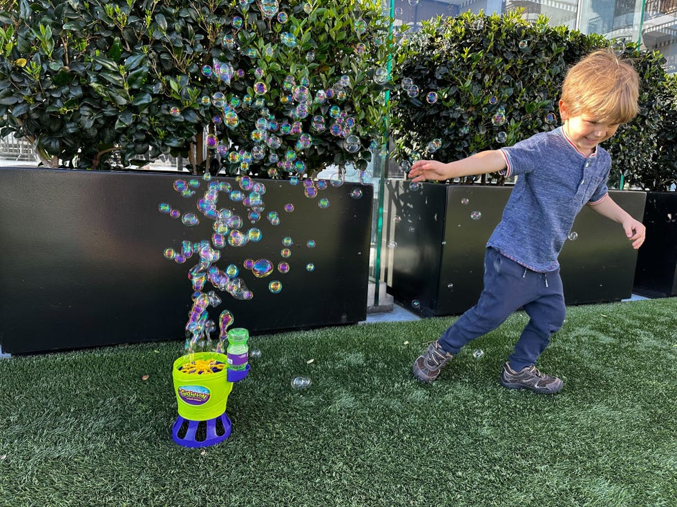 child playing with a gazillion bubble machine outdoors