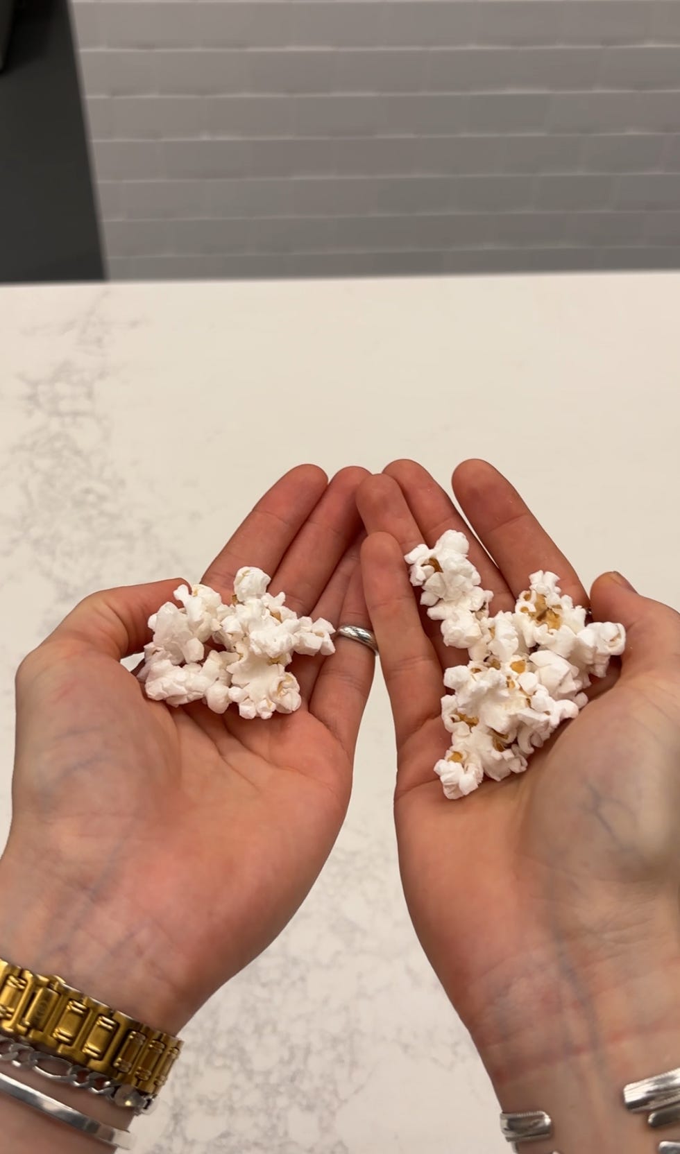 two hands holding popcorn in separate piles