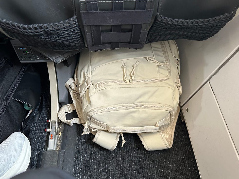 a white bagsmart carry on backpack under the seat on an airplane, good housekeeping's testing of carry on backpacks