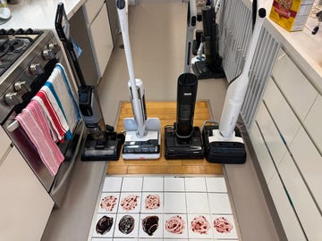 four vacuum mops on the floor with tiles that have chocolate sauce and grape jelly stains