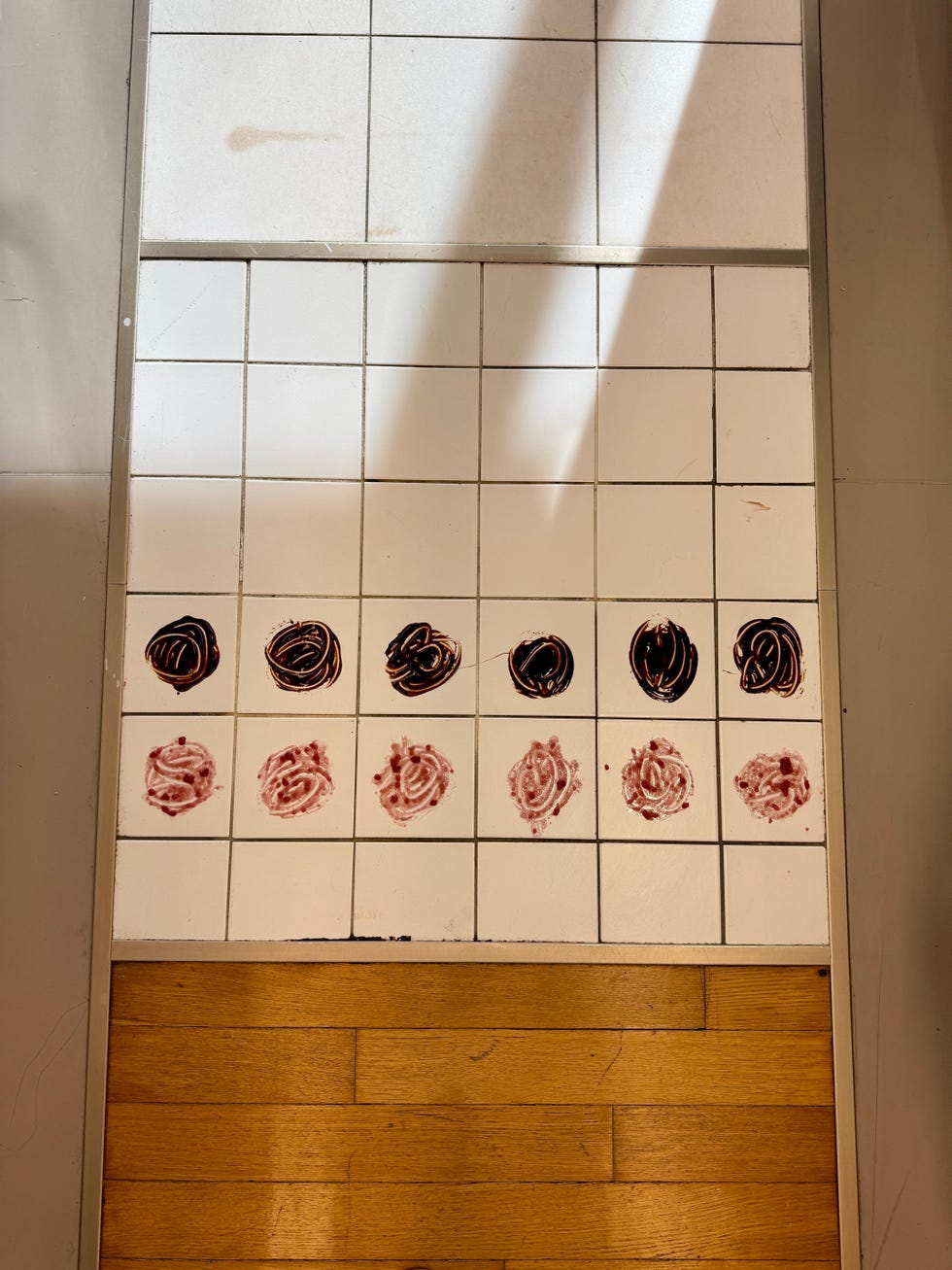 tile floor with circles of chocolate syrup and jelly in the squares