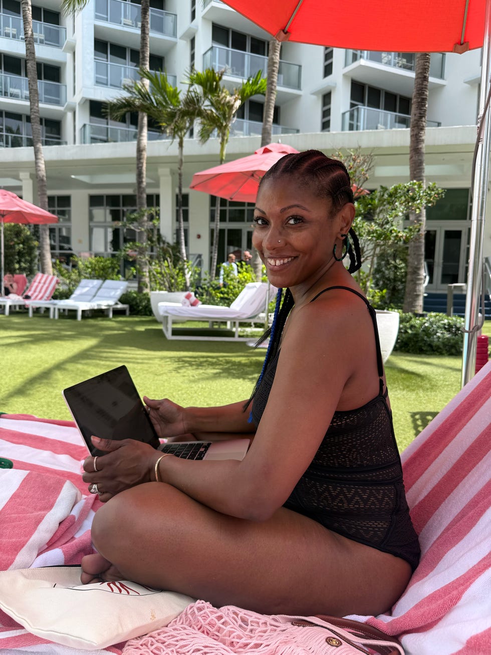 author on her laptop while lounging at the pool