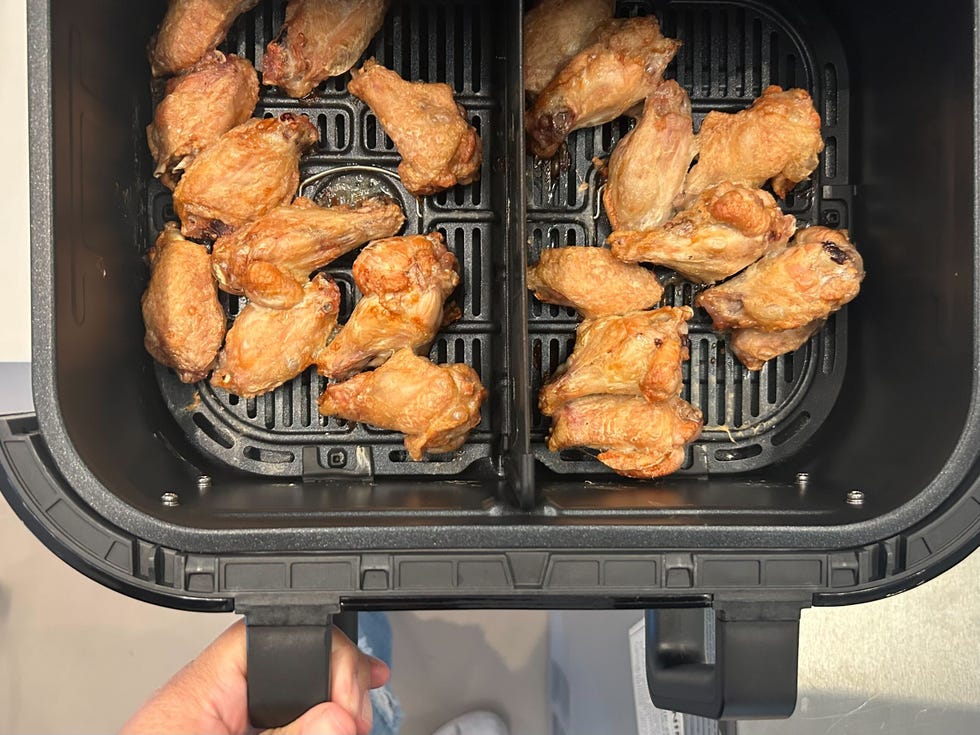 cooked chicken wings in an air fryer basket