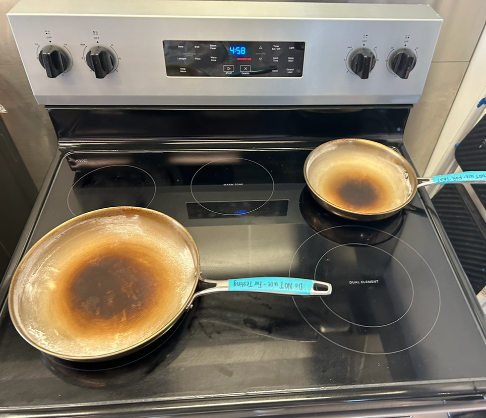 two skillets covered in flour on the electric cooktop during a good housekeeping lab range test.