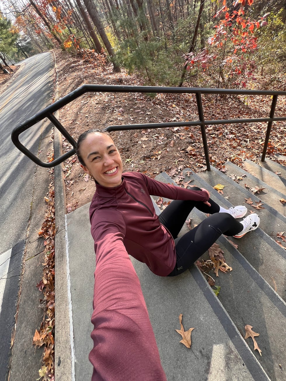 person sitting on stairs in a wooded area