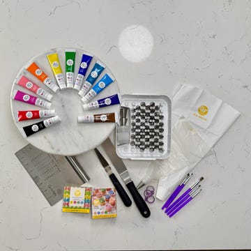 best cake decorating tools various cake decorating tools such as food color, piping tips, spatulas and piping bags on a marble counter