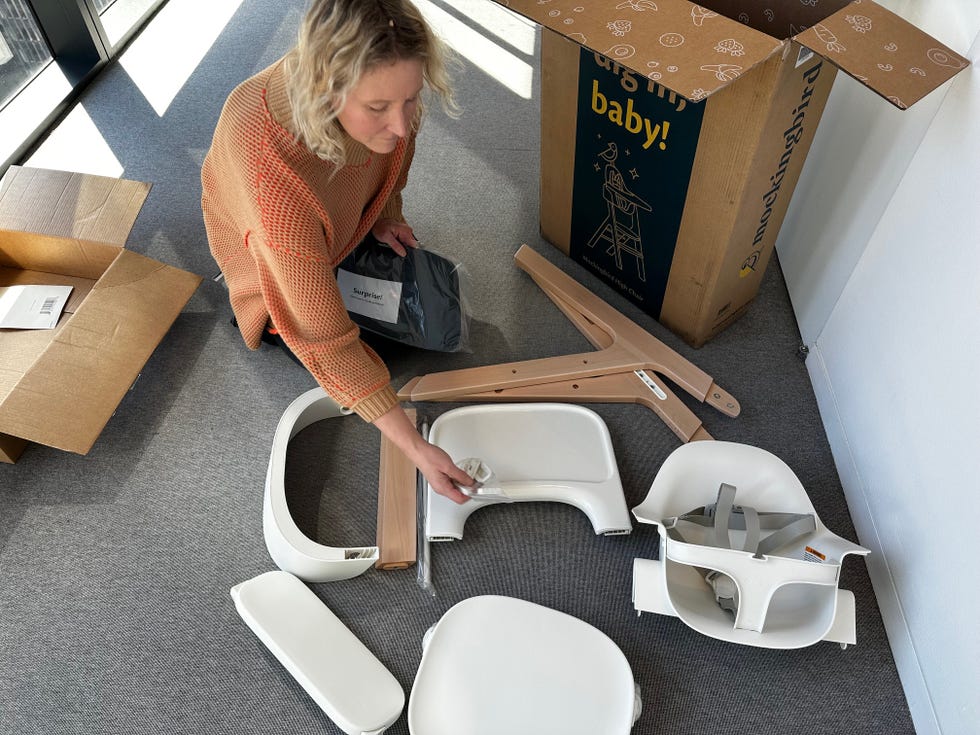 a member of the good housekeeping institute assembles and tests a high chair