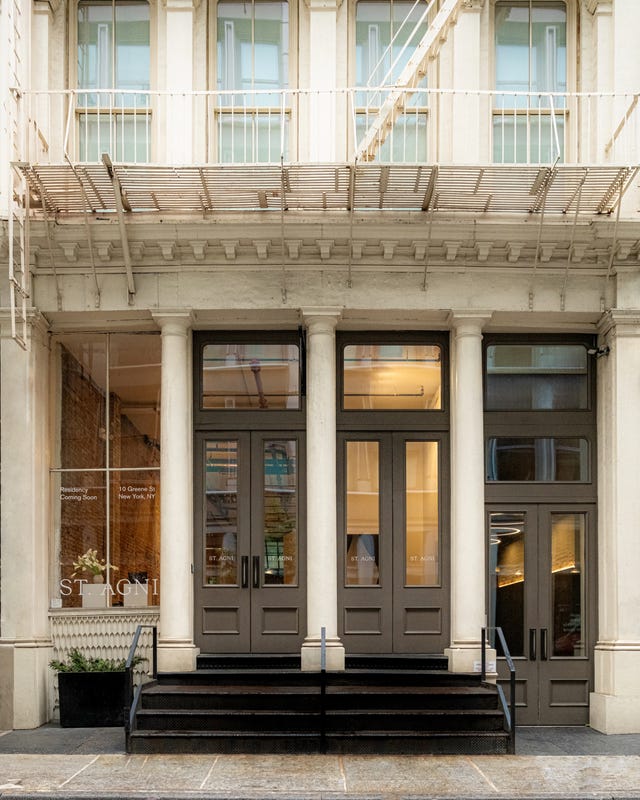 Entrada a un edificio con grandes puertas dobles y una moderna tienda.