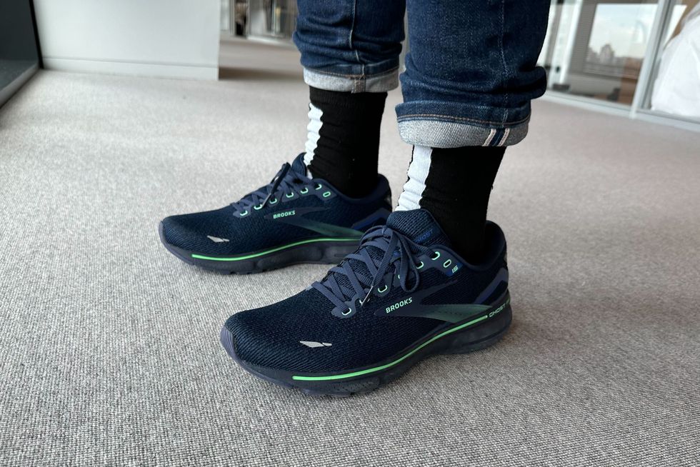 a tester wearing a pair of brooks ghost 15 on a grey carpet, good housekeeping's testing for the best walking shoes