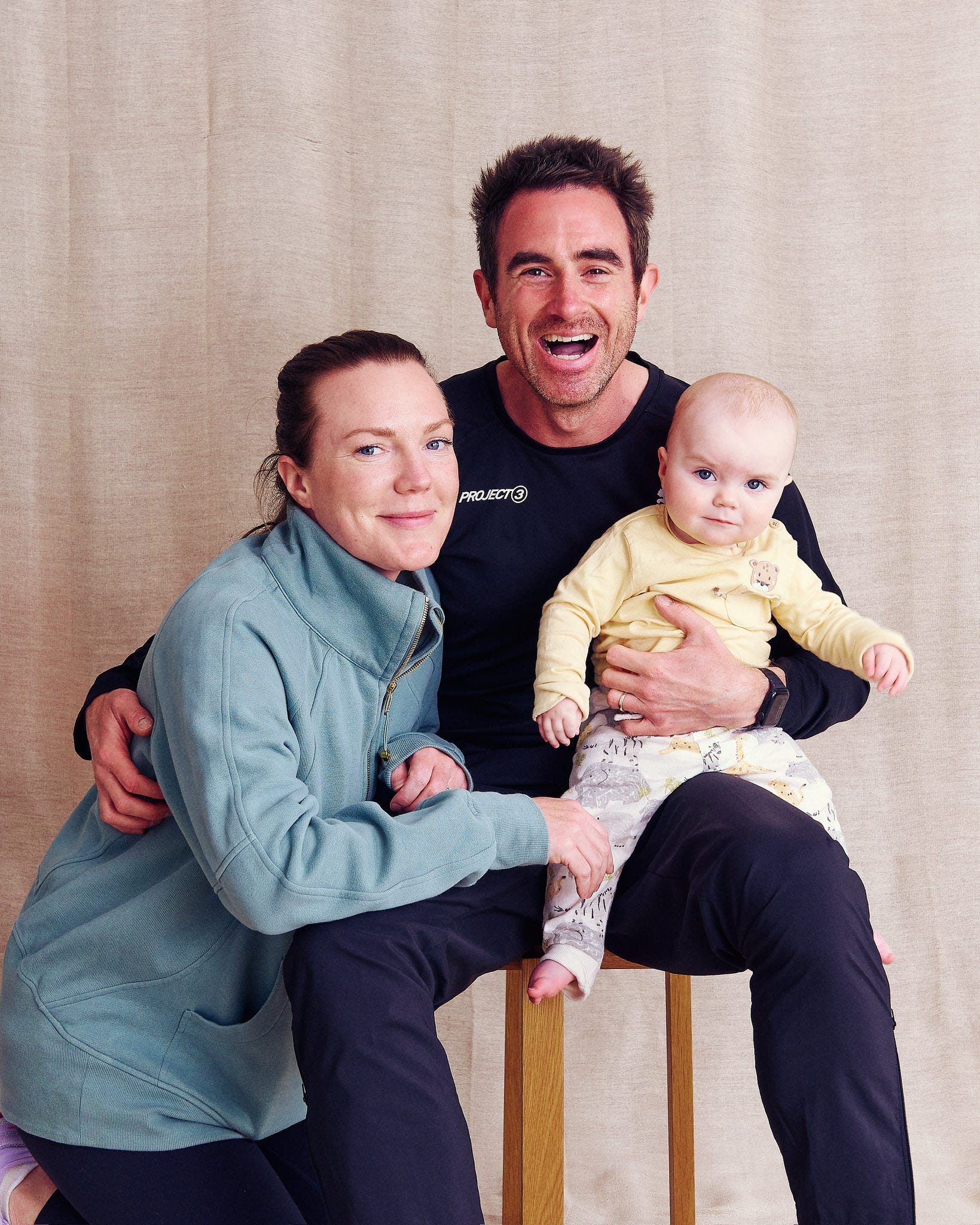 a family photo with a woman and a man holding a baby