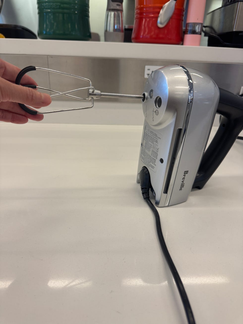 hand inserting a beater into a hand mixer
