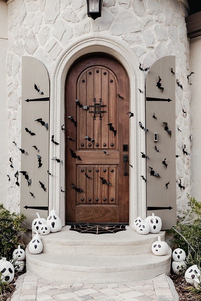 fall front porch with bats and painted ghost pumpkins