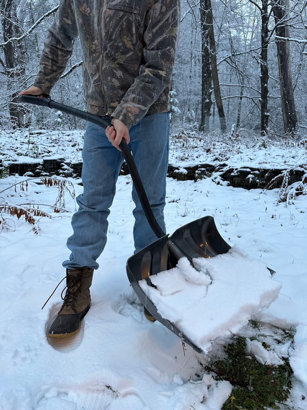 person shoveling snow in a snowy landscape