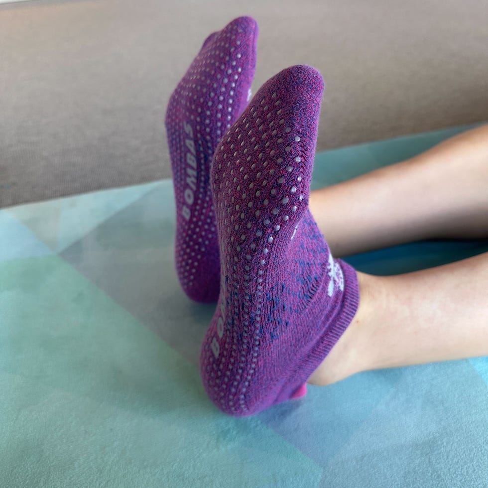 a person wearing purple bomba gripper ankle socks