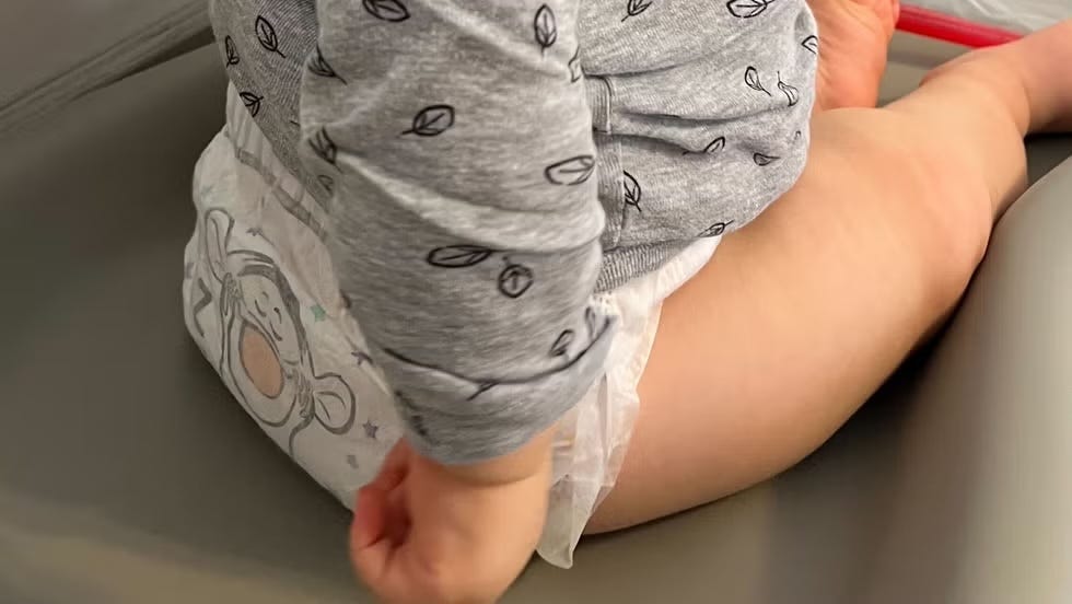 a close up shot of a baby wearing a tigger diaper