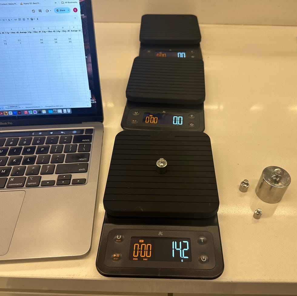 coffee scale testing three coffee scales, one with a weight on it, next to a labtop