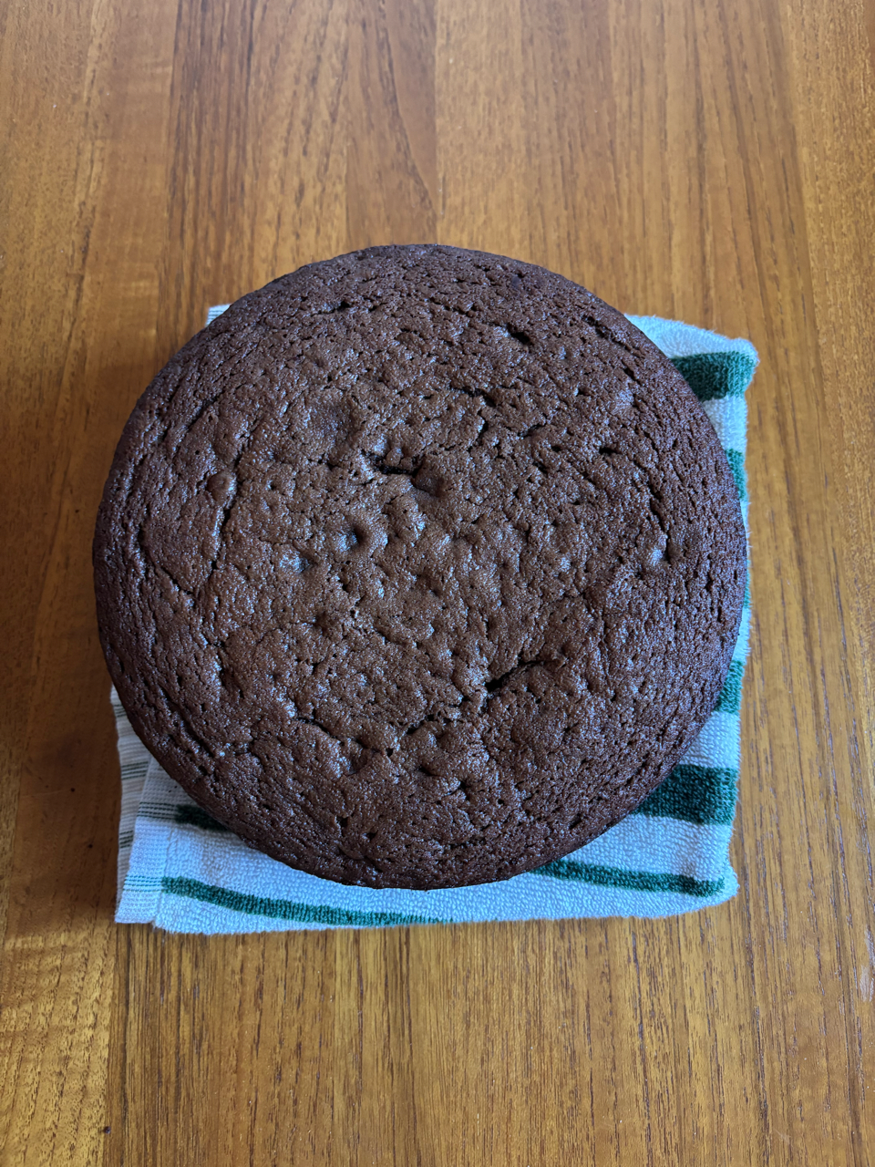 chocolate cake resting on a striped cloth on a wooden surface
